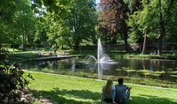 Zwei Menschen sitzen in einem Park an einem See