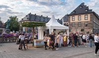 Ein Platz mit Menschen und einem Veranstaltungszelt 