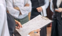 Detailaufnahme einer Person, die eine Liste in der Hand hält