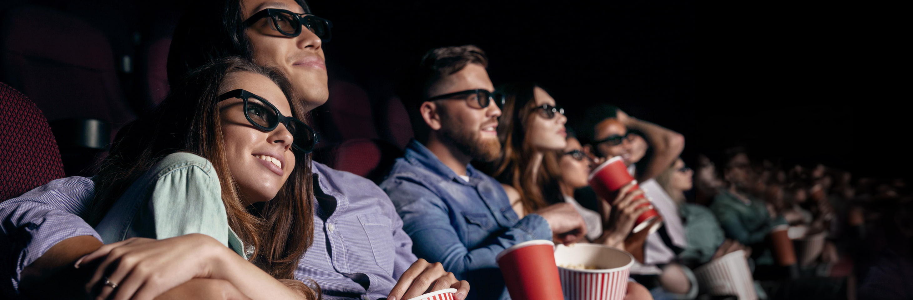 Im Kino sitzende Menschen, die eine 3D-Brille tragen