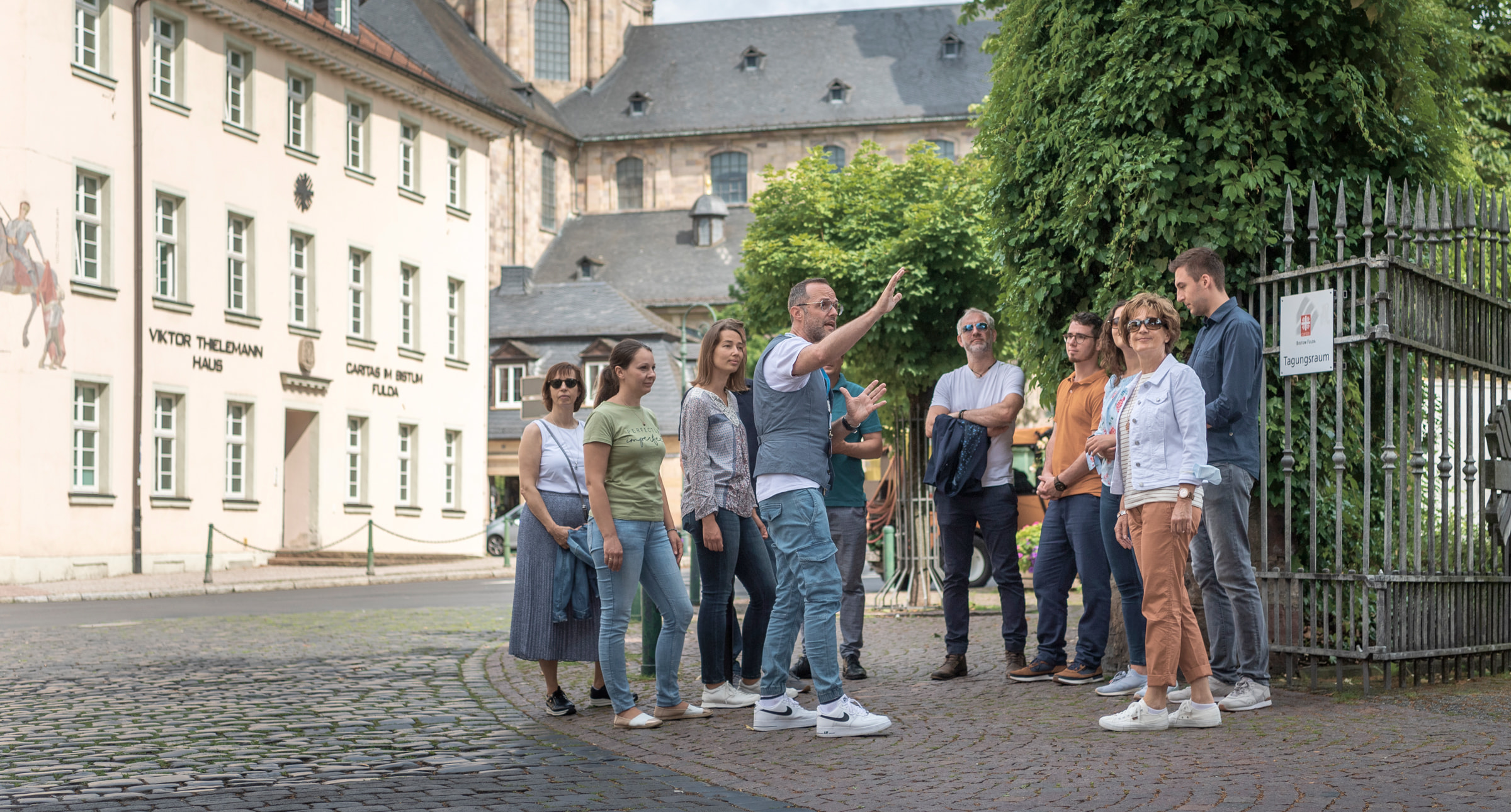 Eine Personengruppe steht zusammen vor einem Gebäude